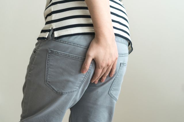 お尻をおさえる男性